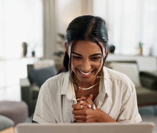 a woman looking at a laptop, excited that she's found quality white label seo services