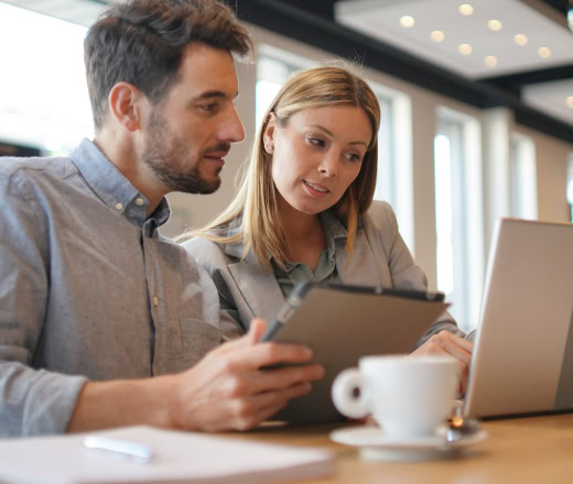 coworkers looking at report from charlotte seo company on laptop